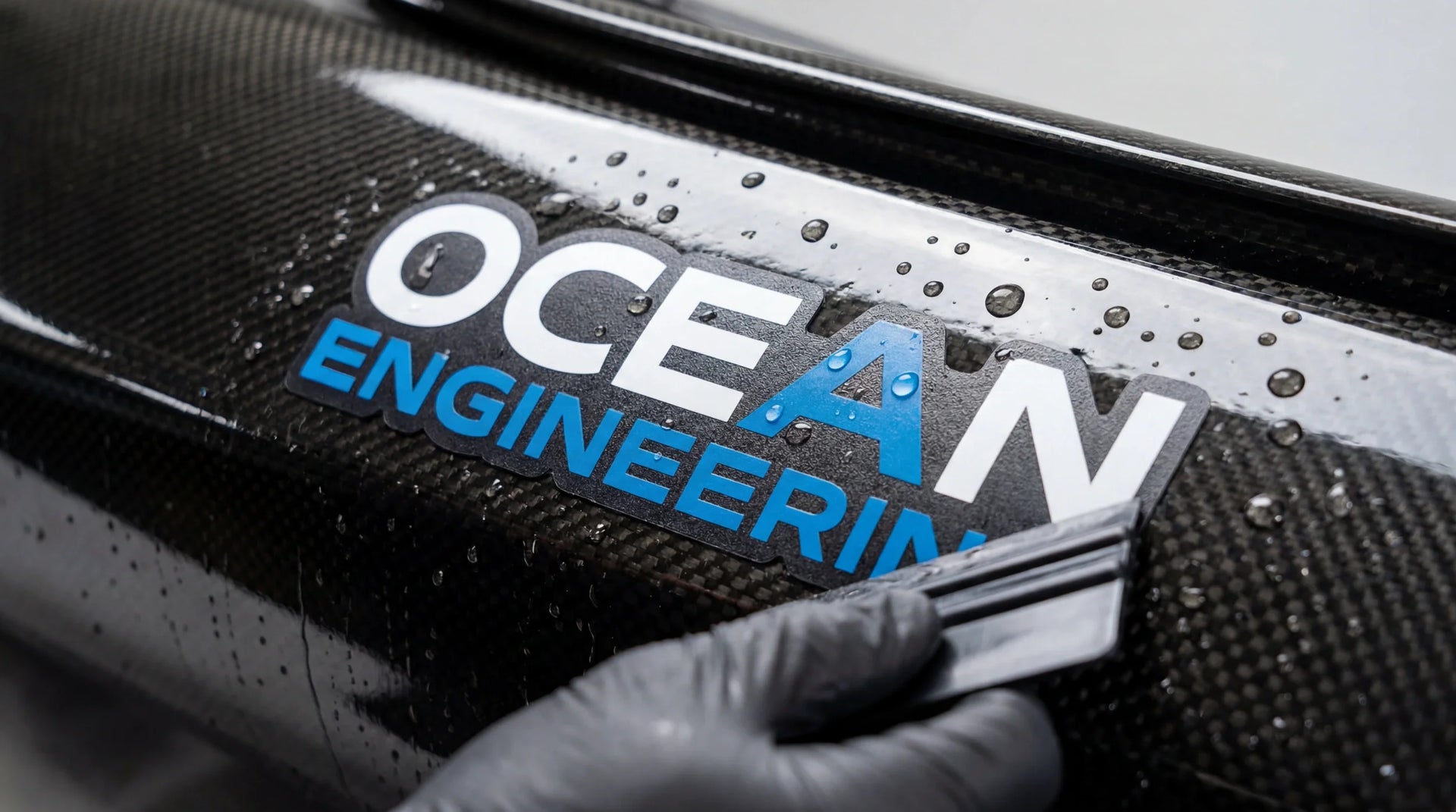 Close-up of a 6-mil custom waterproof polymeric vinyl decal with precise die-cut edges applied on an ocean kayak hull, demonstrating resistance to saltwater and UV light.