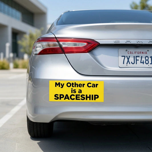 A colorful custom bumper sticker with a witty slogan applied to the rear bumper of a clean silver car.