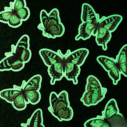 Okaystickers Glow in the dark butterfly vinyl stickers emitting green phosphorescent glow on black background
