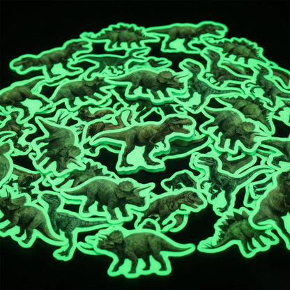 Okaystickers Glow in the dark dinosaur vinyl stickers scattered on black background emitting green phosphorescent glow