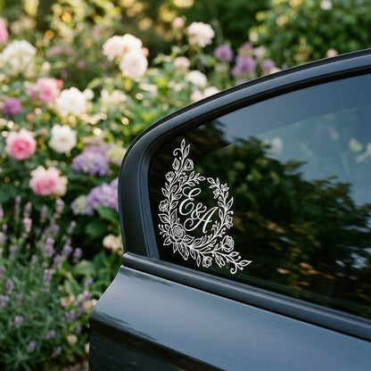 A minimalist white vinyl monogram sticker on the corner of a car's side window, showing a clean and elegant branding.