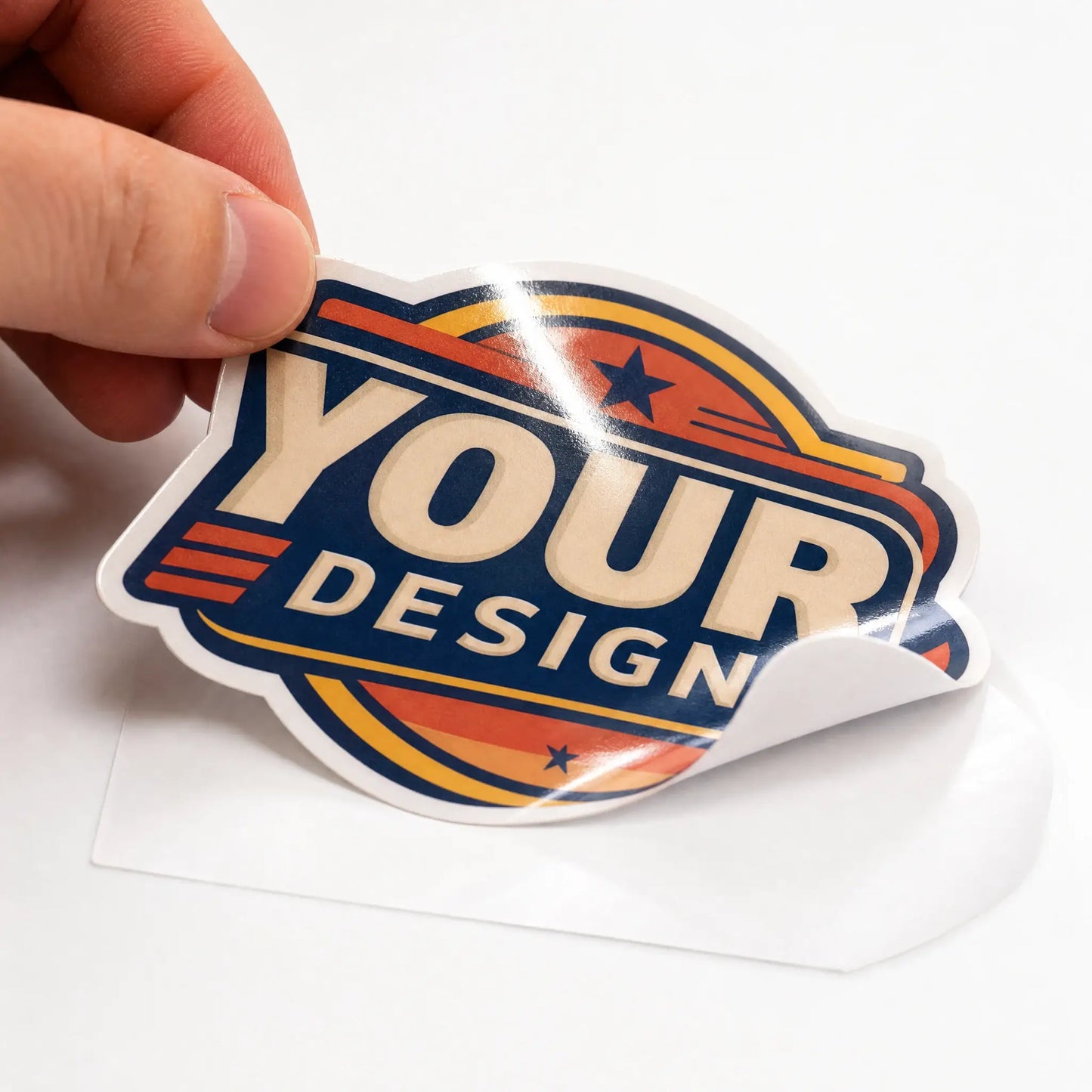 A hand peeling a custom die-cut vinyl sticker off its white backing paper showing adhesive and vinyl flexibility